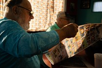 A man reads The Hawk Eye newspaper in a diner.