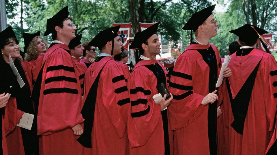 A photo of graduates lined up in red and black graduation robes.