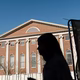 Photograph of someone in silhouette in front of a Harvard University building