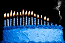 Candles melting down on top of a blue birthday cake