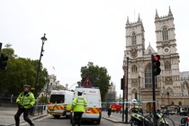 Police officers stand at a cordon after a car crashed outside the Houses of Parliament in Westminster on August 14, 2018.