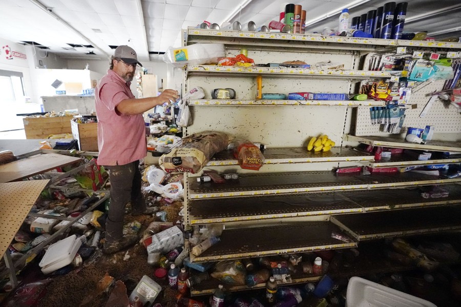 A man walks through his flood-damaged store.