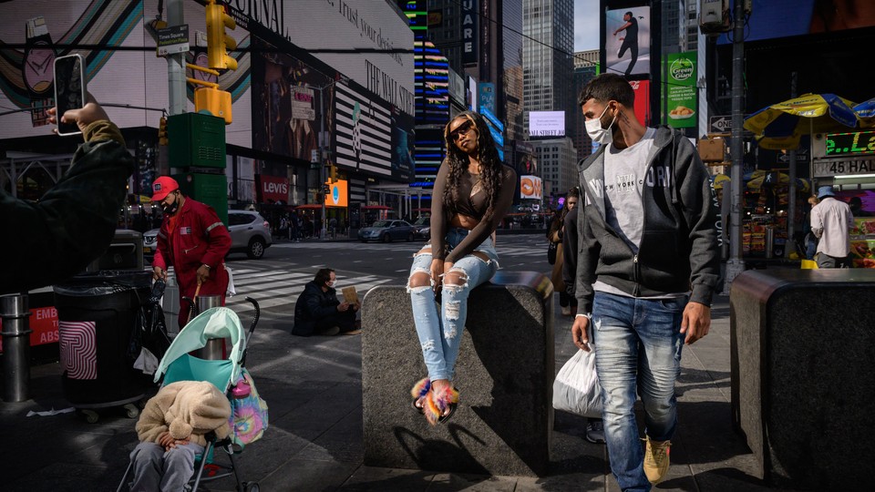 A man wearing a mask walking through Times Square