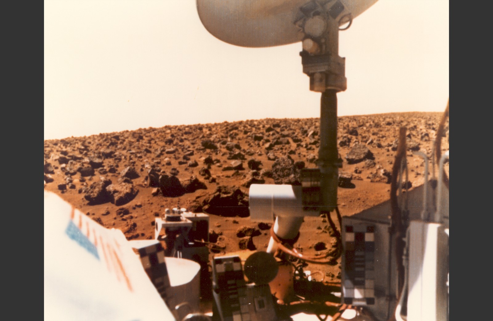 The rocky surface of Mars, seen with parts of a spacecraft in the foreground, in 1976