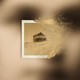 A faded image of a house that's turning into dust, superimposed on a blurry image of a woman's face