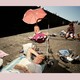 Photo of a tired-looking mother at a beach with her baby, who is crying