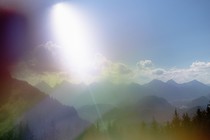 Photograph of a mountain range on a sunny day, image quality looks like it's being seen under a kaleidoscope