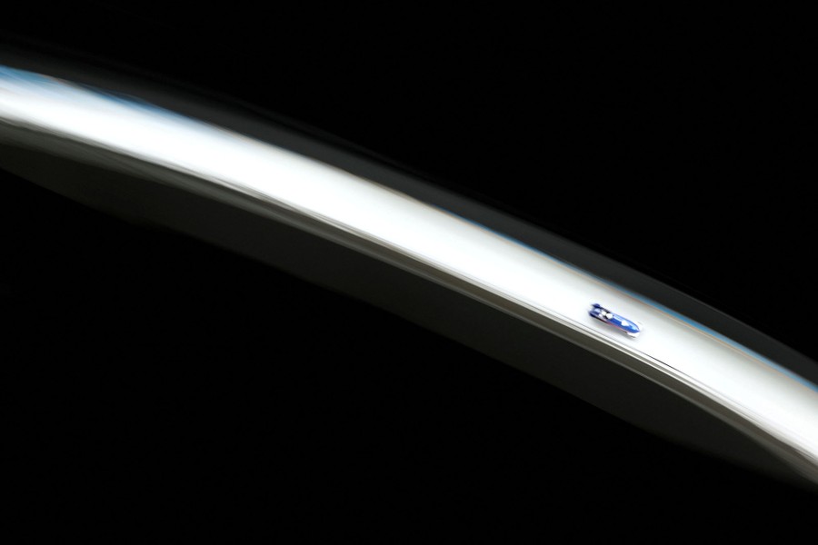 A slightly blurred image of a bobsleigh speeding down a long ice track.