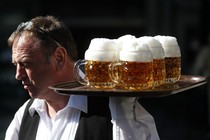 A waiter carries a tray of beers 