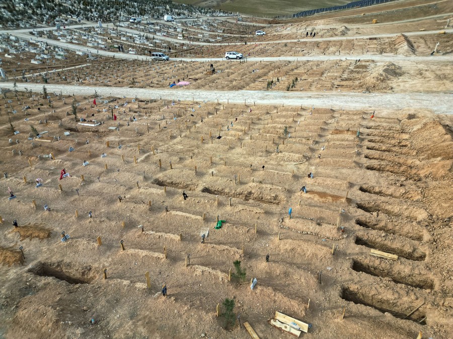 A wide view of a cemetery with many newly dug graves