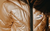 An "I Voted" sticker on a golden puffer jacket