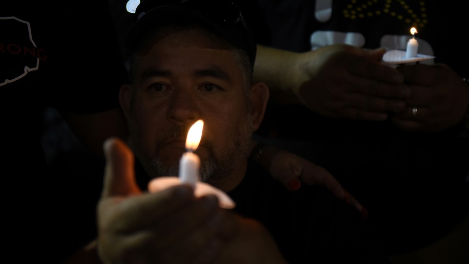 Man holding a candle at vigil after mass shooting in El Paso