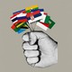 A fist holding several small flags including Serbia’s