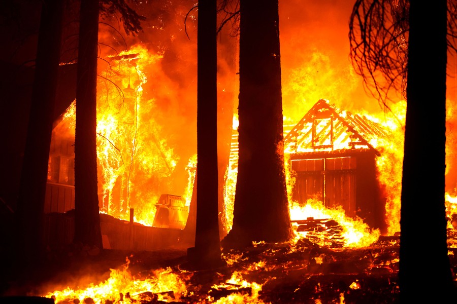 Several buildings go up in flames in the middle of a forest fire.