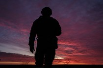 Silhouette of soldier over a sunset sky