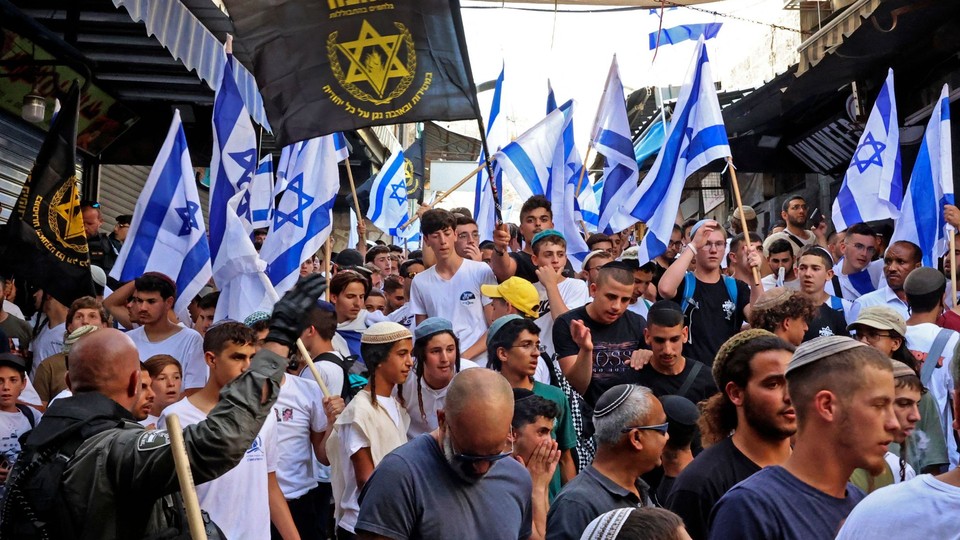 Demonstrators in Jerusalem wave the black banner of the far-right Jewish group Lehava at the Jerusalem Day Flag March.