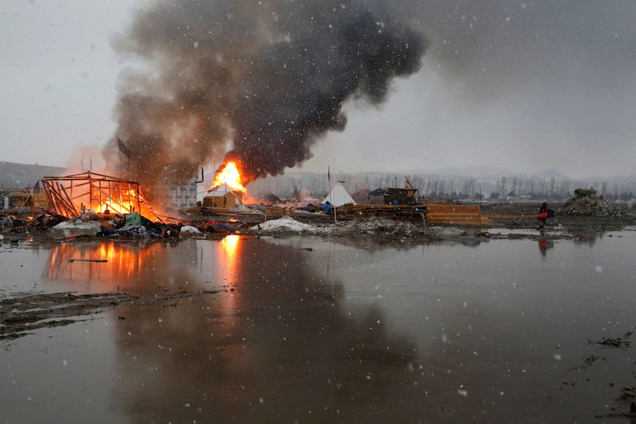 Buildings burn after being set alight by protesters preparing to evacuate the main opposition camp against the Dakota Access oil pipeline on February 22, 2017.