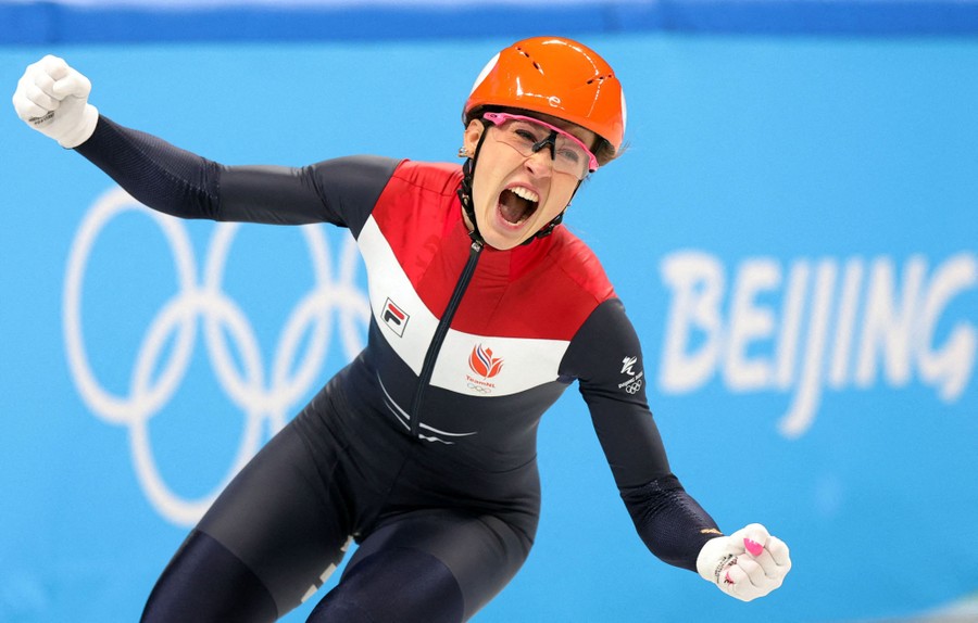 A speed skater celebrates while still on the ice.
