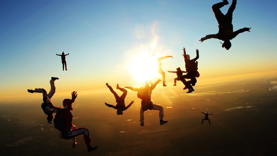 A group of skydivers pose as they fall through the air