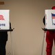 Two voters stand at polling booths