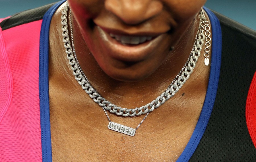 A close view of Serena Williams wearing a necklace reading "Queen"