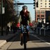 A woman rides a bicycle down a bike lane in Denver