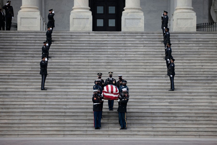 Soldiers carry a coffin draped in an American flag down the U.S. Capitol steps.