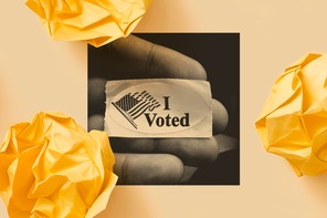 A hand holds an "I Voted" sticker.