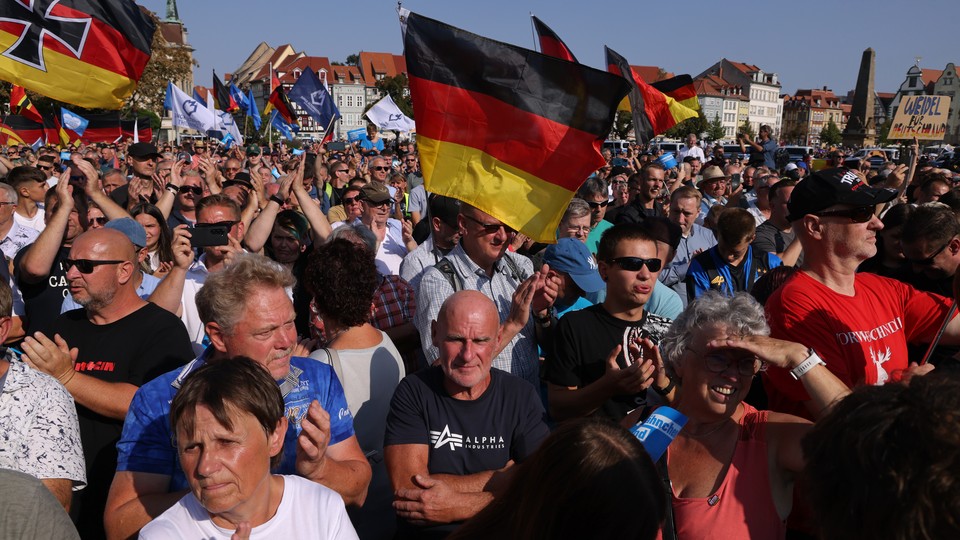 A photo of AfD supporters waving German flags at a rally ahead of the 2024 election.