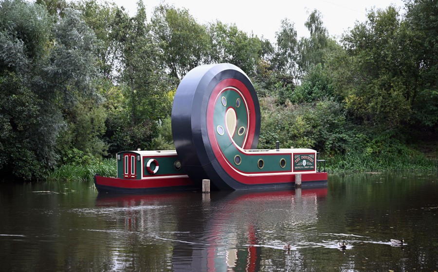 An art installation made of a canal boat that has apparently been twisted into a loop in the middle.