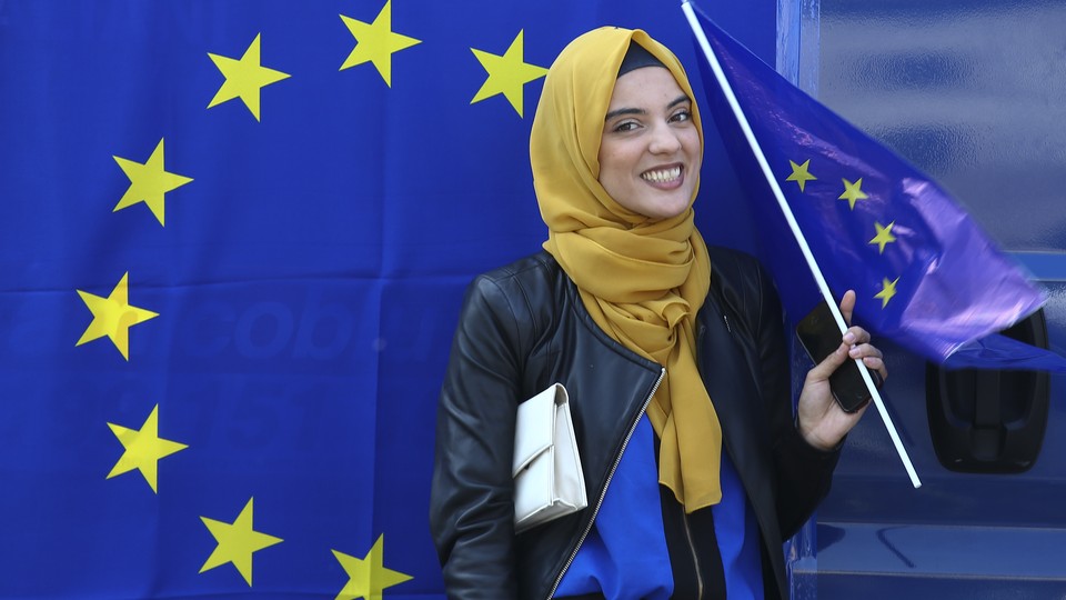 A Muslim woman holds a European flag during a pro-EU demonstration.