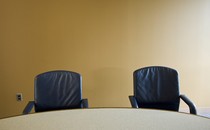 Photo of two empty chairs at a boardroom table