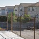 Barbed wire fencing, an empty lot, and a row of houses in a neighborhood on the South Side of Chicago.