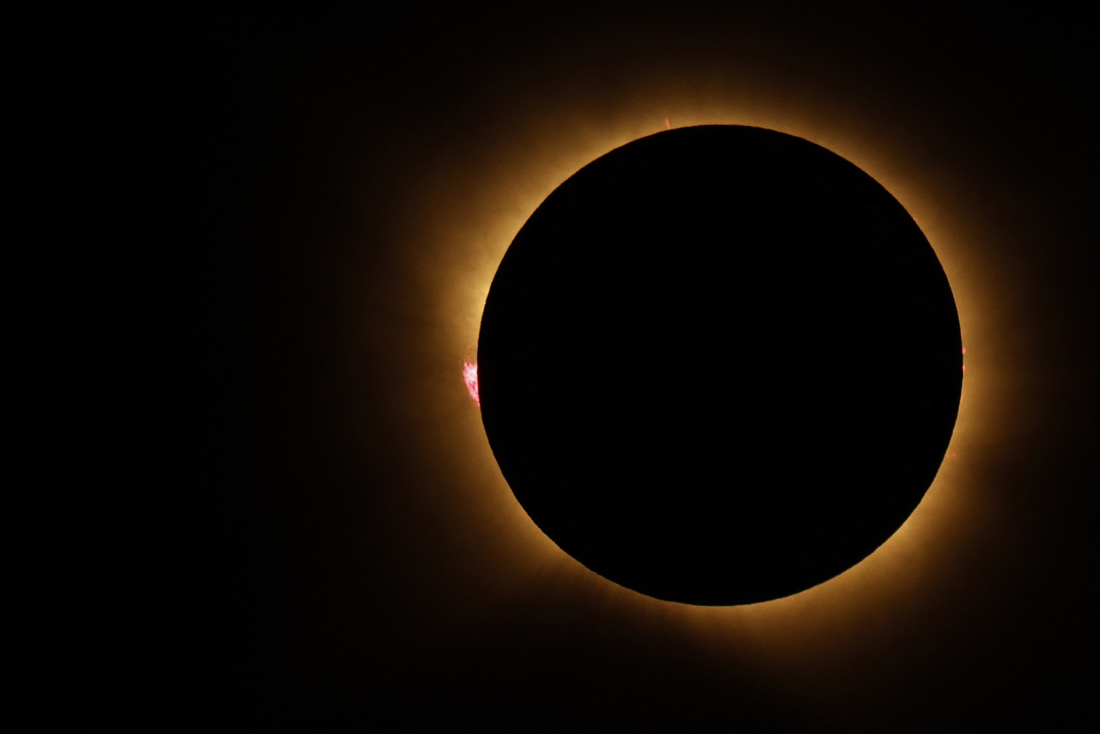 The Sun’s corona glows as the moon completely blocks the sun.