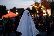 A man in a ghost costume marches in the annual Nyack Halloween Parade, in October 2016.