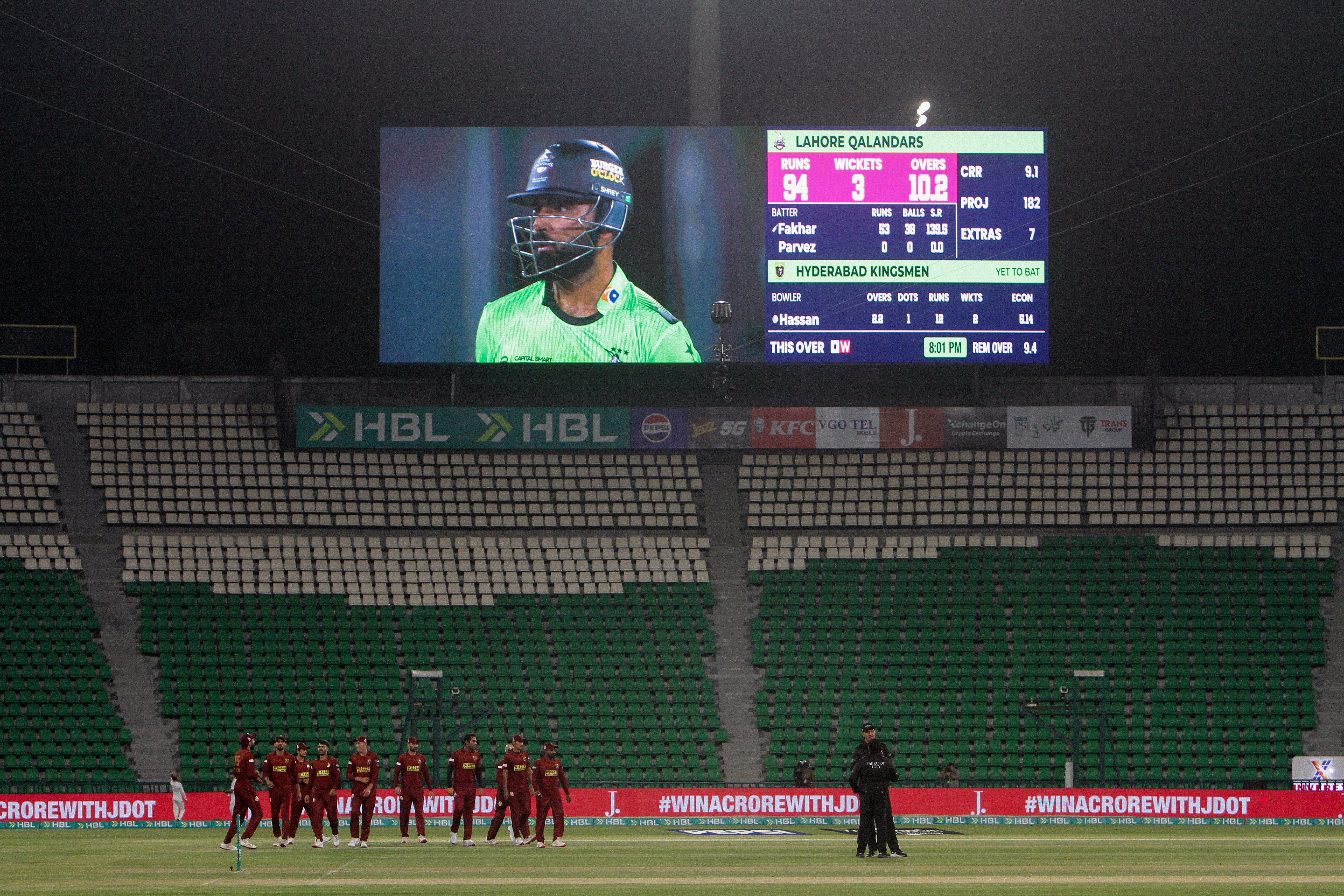 A nighttime cricket match in a deserted stadium