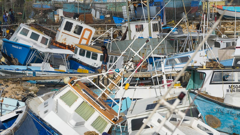 A fisherman looks at fishing vessels damaged by Hurricane Beryl at the Bridgetown Fisheries in Barbados on July 1, 2024.