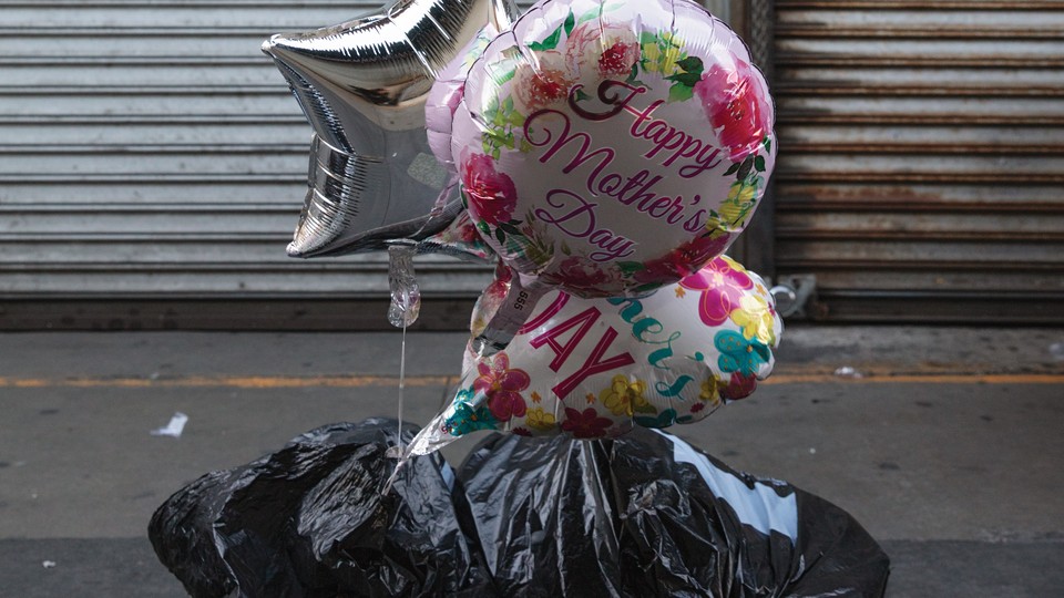 Balloons with the words Happy Mother's Day are on the ground stuff in a trash bag