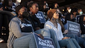A photo of young people holding signs supporting Stacey Abrams
