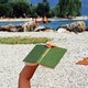 A photo of a person reading outdoors on a beach.