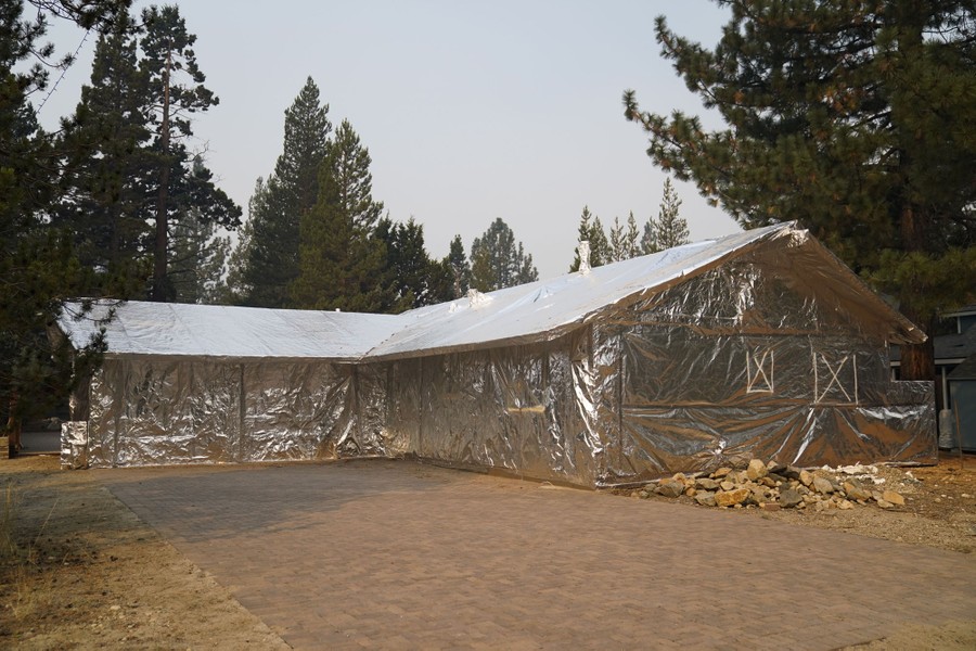A structure is seen completely wrapped in reflective foil material.