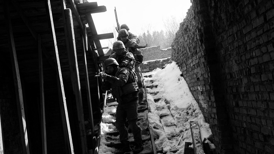 Black-and-white photo of Ukrainian soldiers descending a snow-covered staircase in single file