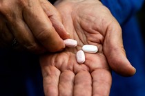 Close-up photo of hands holding Paxlovid pills