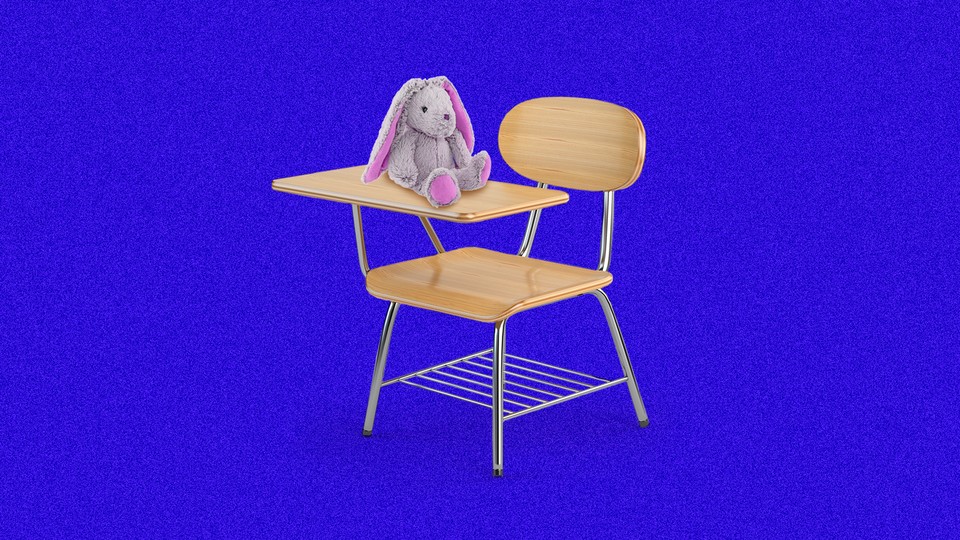 A school desk chair with a stuffed bunny placed on the writing surface