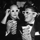 Two moviegoers wearing 3D glasses