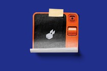 Illustration of an image of the Rabbit R1 printed on a piece of paper and stuck with tape onto a background