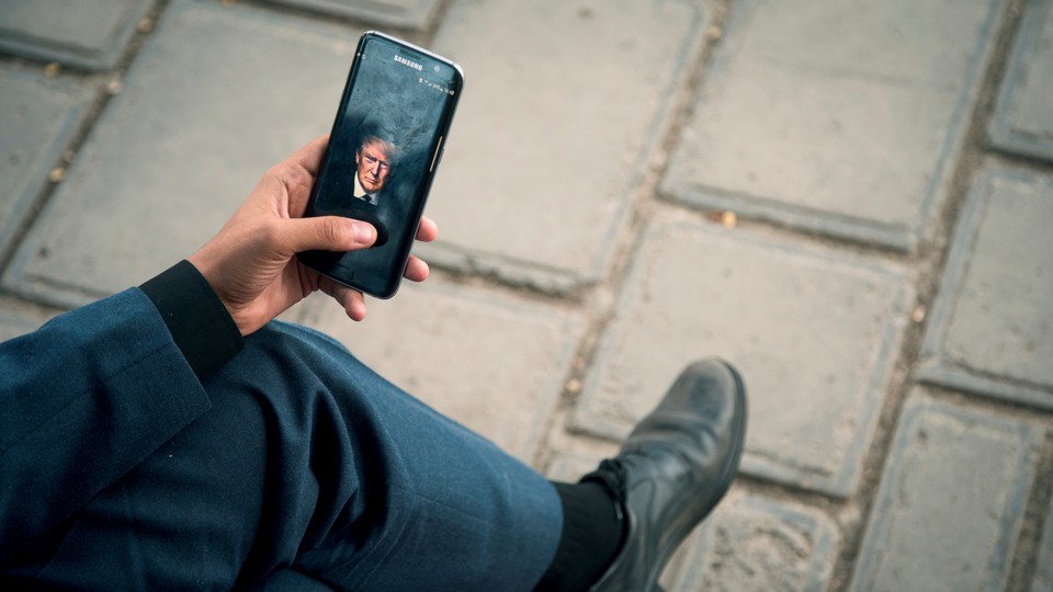 A man displays a picture of President Trump on his phone.