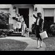 Photo of a mother leaving for work, waving goodbye to her husband and children