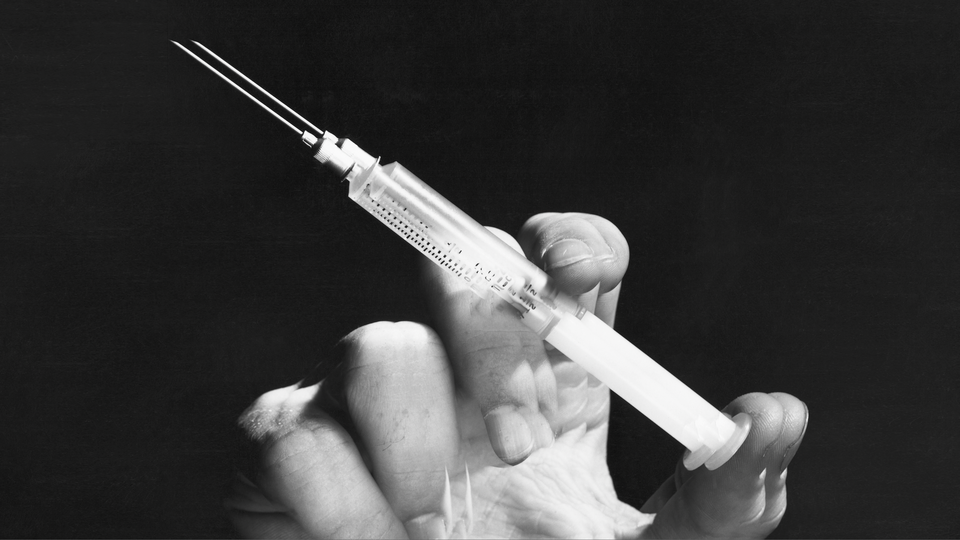 a hand holding a syringe