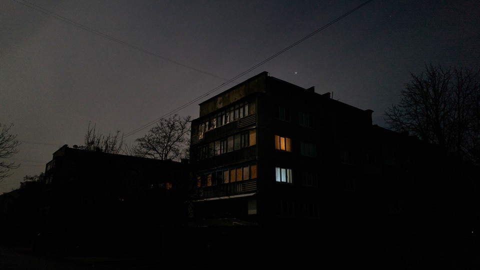 A building with a few lights on inside at dusk